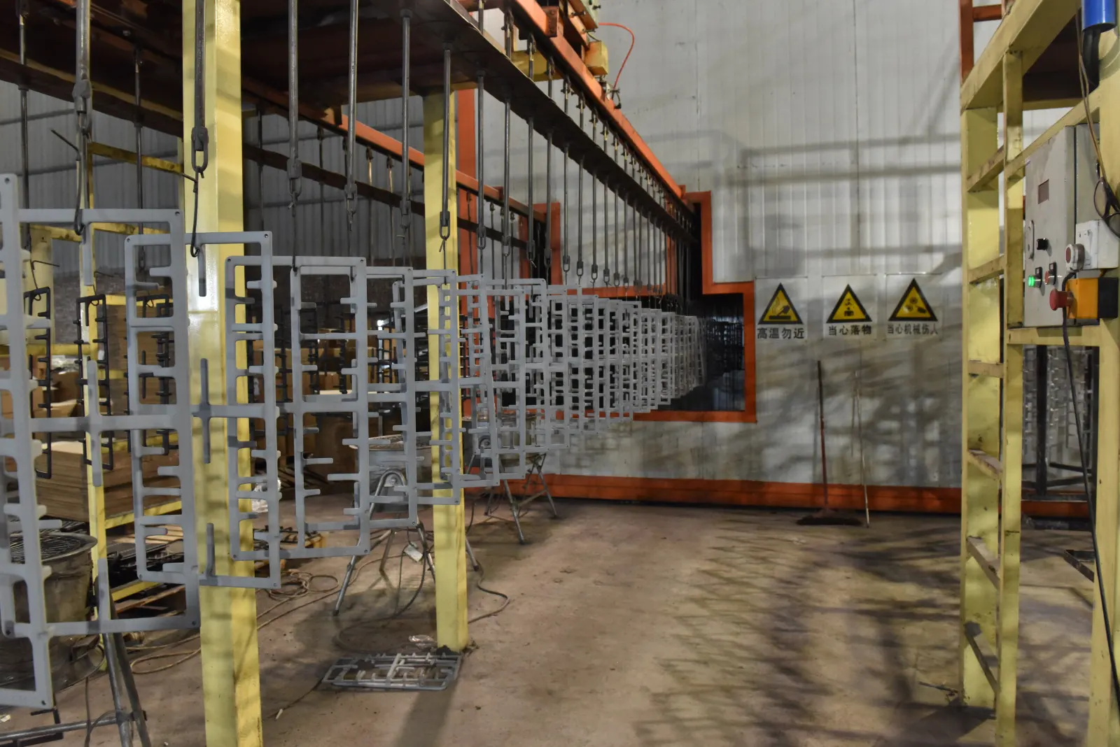 Cast iron parts hanging on racks along a coating or surface treatment line